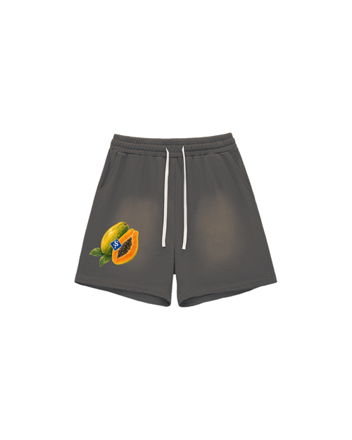 Sun-faded grey shorts with white drawstring; a whole and cut papaya with black seeds sits low on the left thigh.